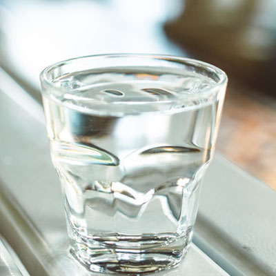 Hydrovos brings Clean Water for You - Focused image of a glass of water with a blurred background